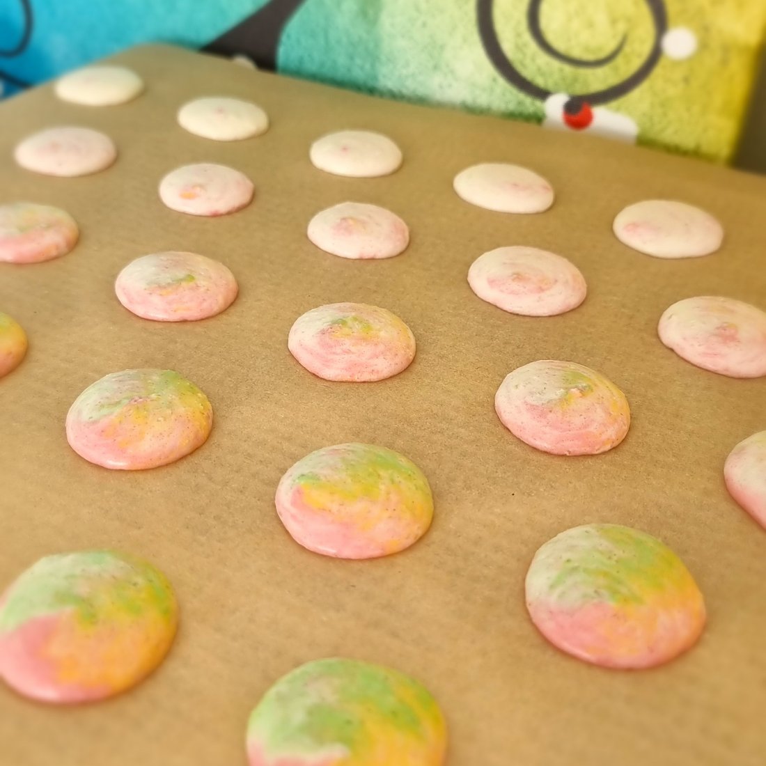 Macaron pastello disposti in fila prima della cottura