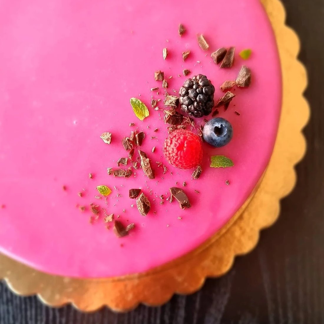 Torta moderna rossa decorata con frutti di bosco